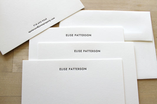 Set of minimalist letterpress stationery with centered name layout and matching envelopes