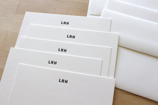 Set of personalized business letterpress stationery with bold initials and matching envelopes
