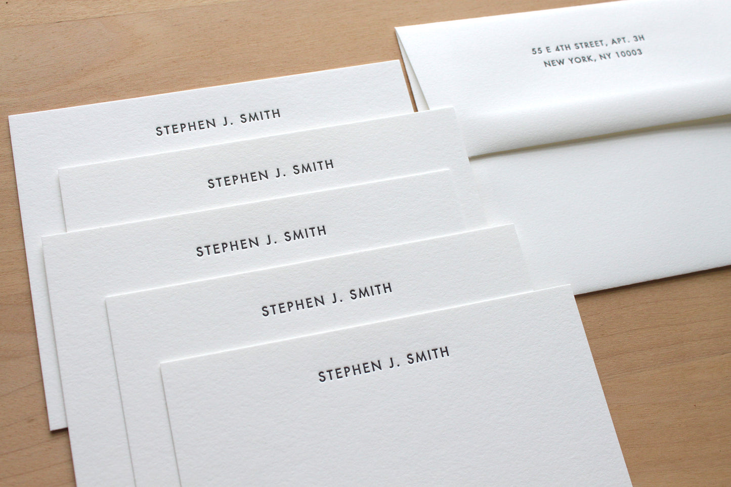Stack of Futura style customized letterpress stationery with matching envelope