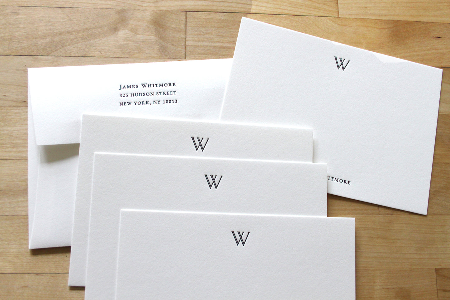 Personalized letterpress notecards with double-stroke W initial, fanned stack with matching return address envelope, cotton paper stationery for professionals
