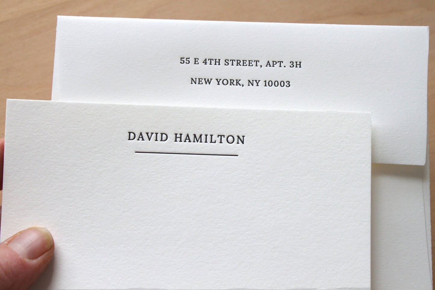 Close-up of deep letterpress impression on business notecard, cotton paper texture