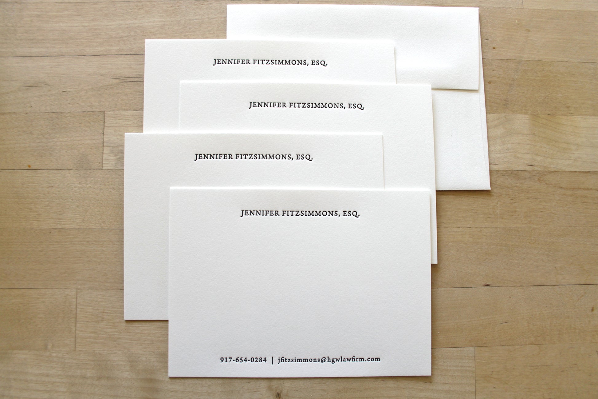 Set of traditional serif professional letterpress stationery with centered layout and matching envelopes