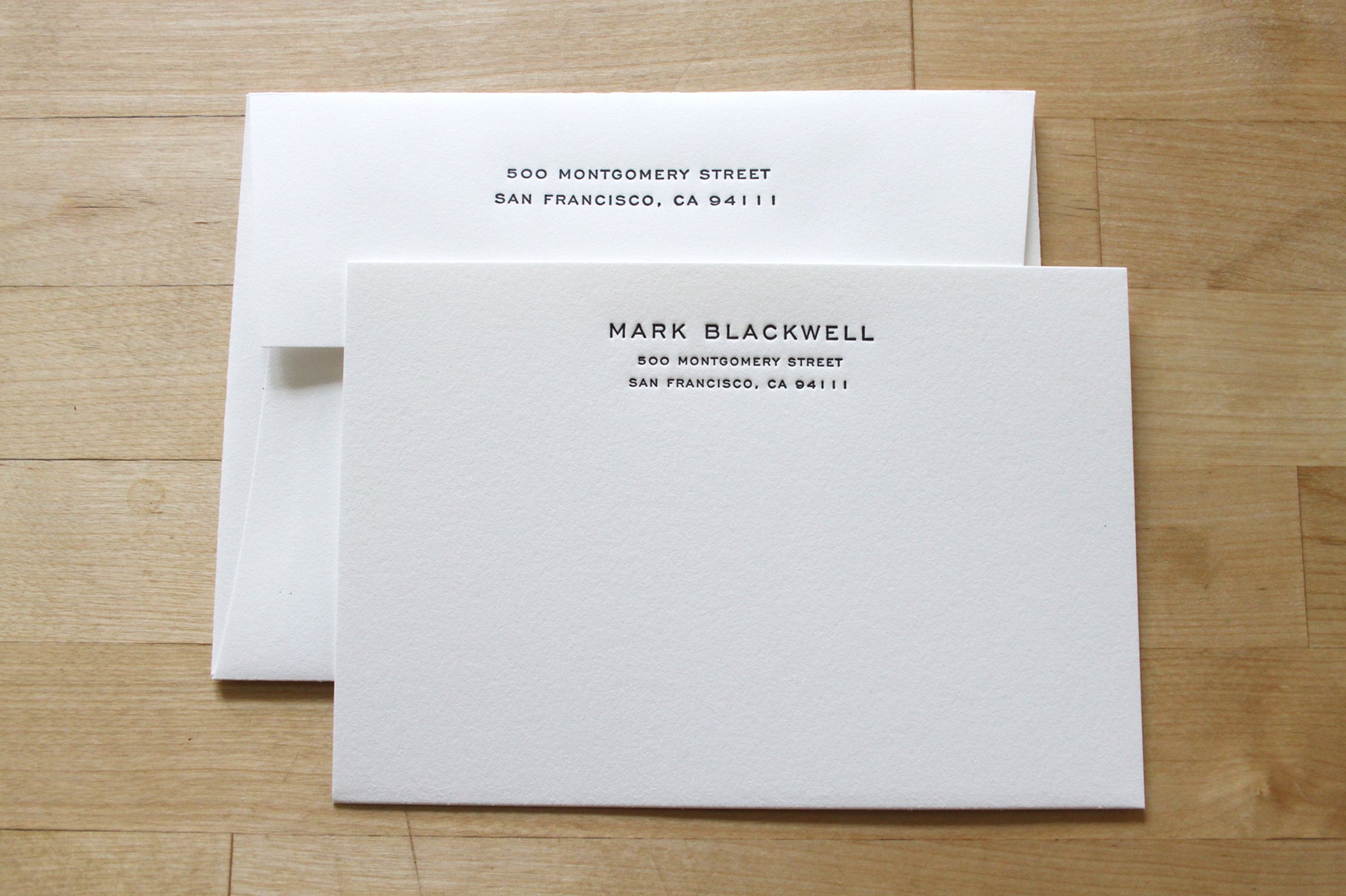 Close-up of Engraver's Address letterpress notecards showing bold engraver's type name with smaller cap address, handcrafted professional stationery on cotton paper