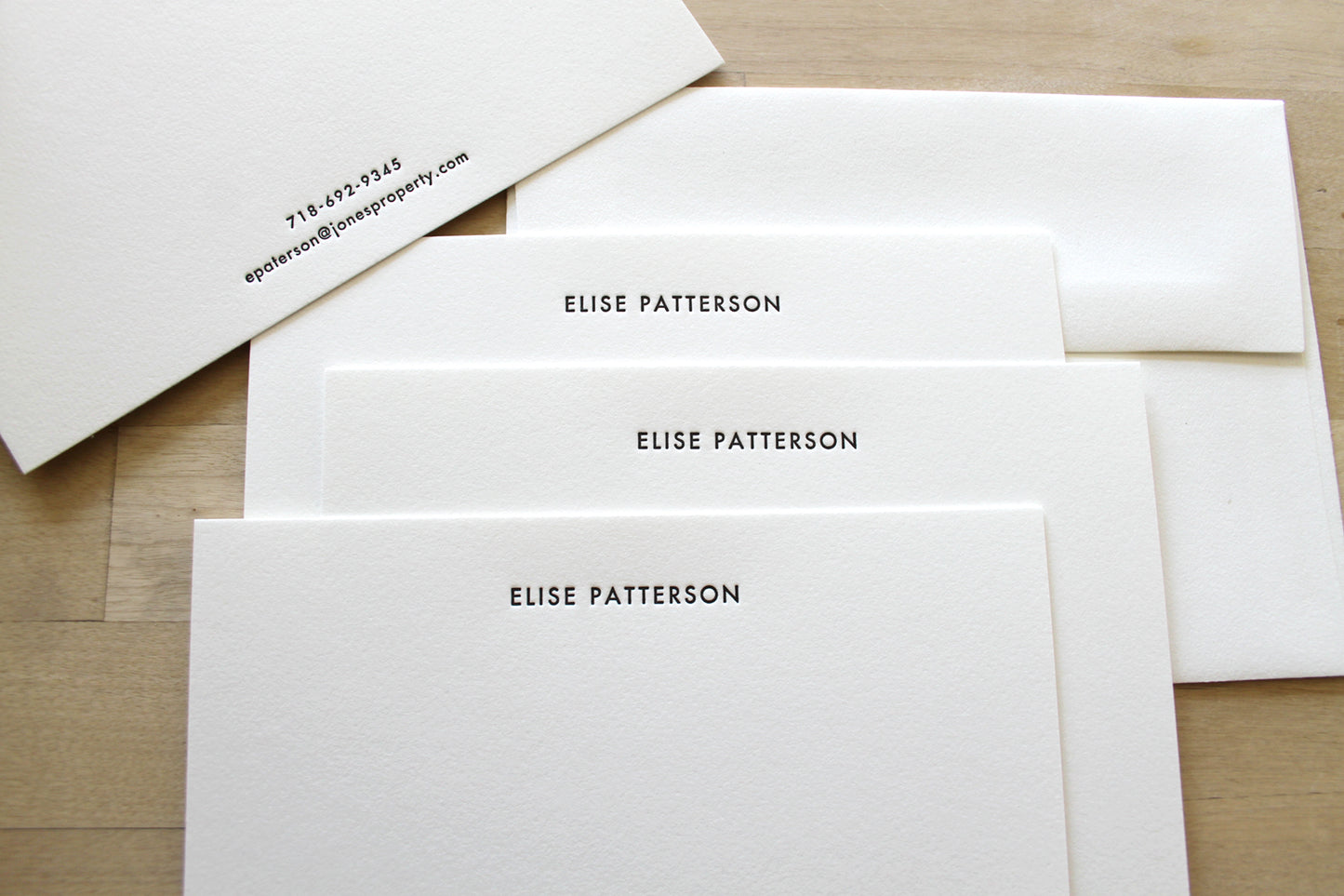 Set of minimalist letterpress stationery with centered name layout and matching envelopes