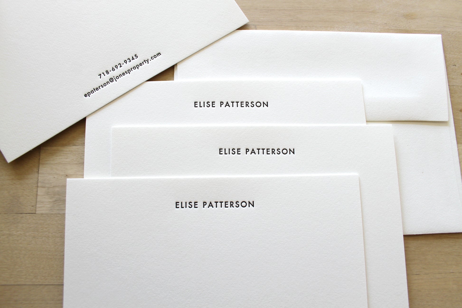 Set of minimalist letterpress stationery with centered name layout and matching envelopes