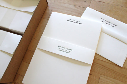 Personalized letterpress letter sheets with matching printed envelopes on wood table