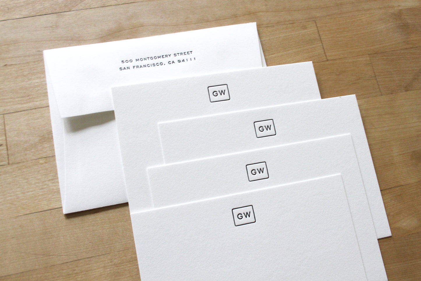 Close-up of Bound Initials letterpress notecards showing boxed initial design with return address envelope, handcrafted professional stationery on cotton paper
