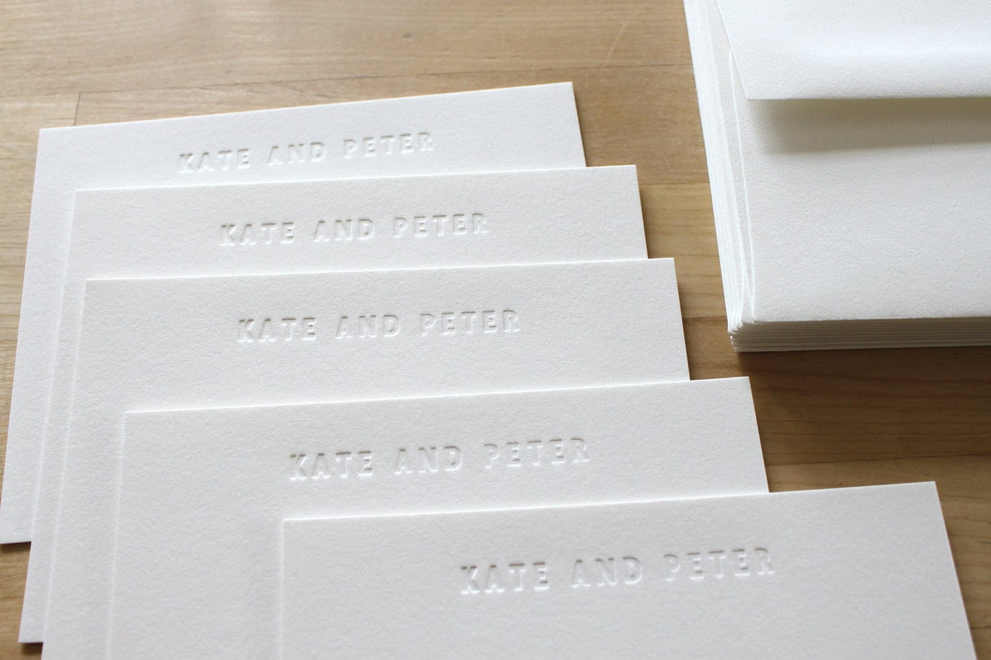 Close up of blind embossed bold type letterpress impression showing name in cotton paper