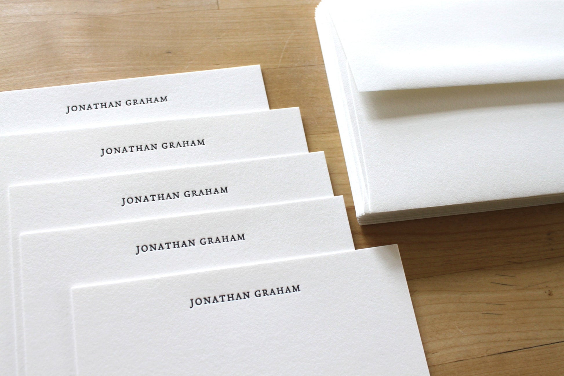 Fan of traditional personalized letterpress notecards with name in classic serif font on cotton paper