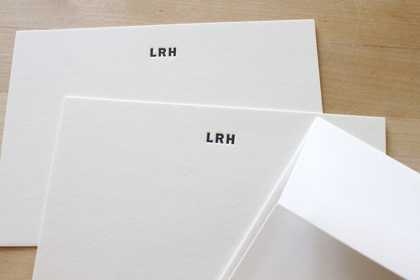 Sharp letterpress impression of bold type initials on premium recycled cotton notecard