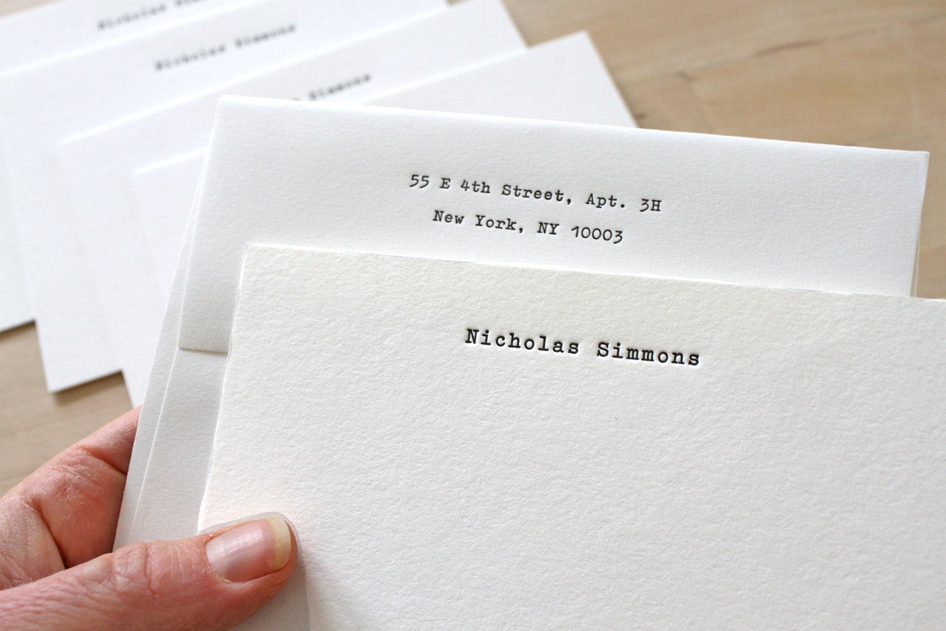 Hand holding typewriter style personalized letterpress notecard with name on cotton paper